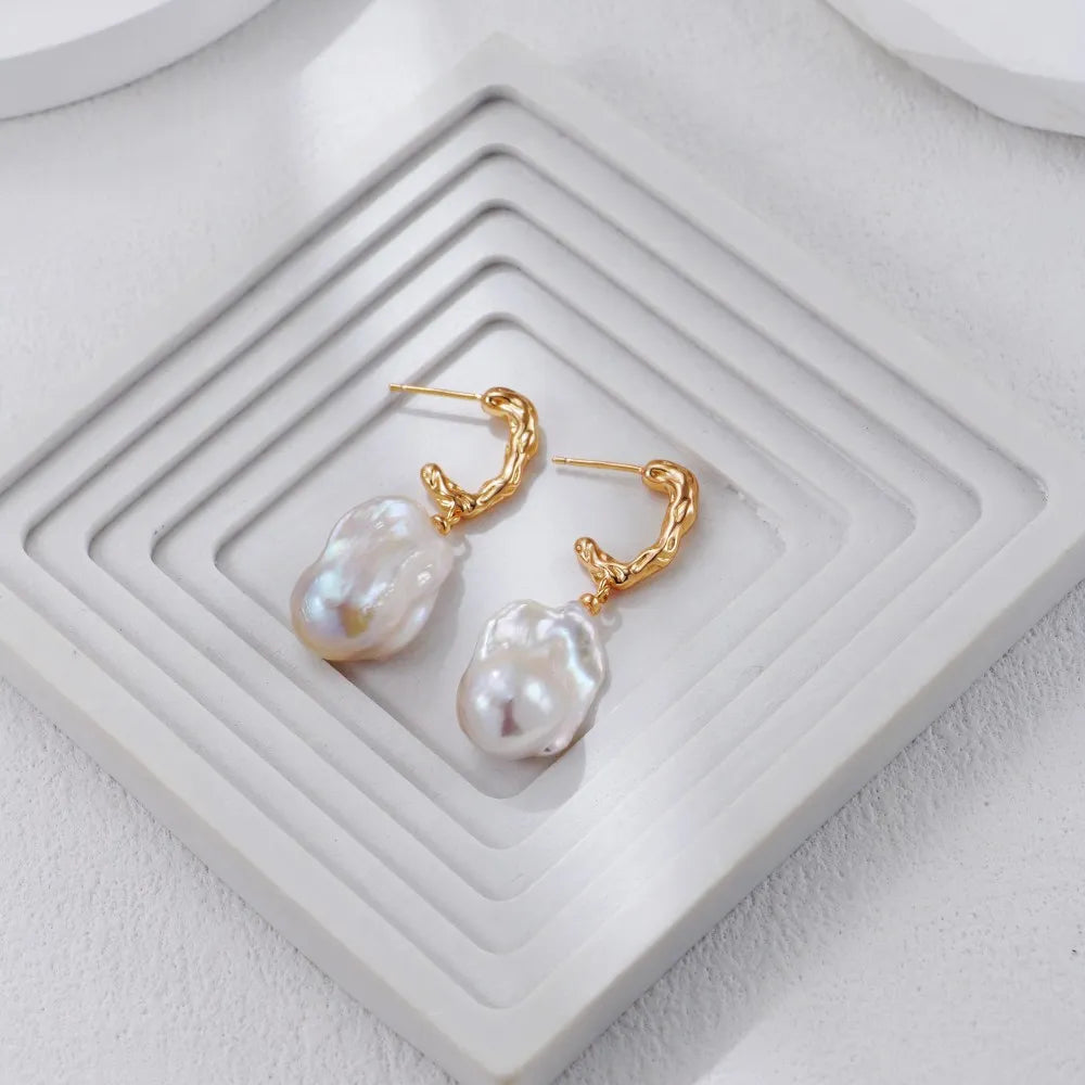 Gold-tone S925 Silver Baroque Pearl Drop Earrings on a white geometric stand