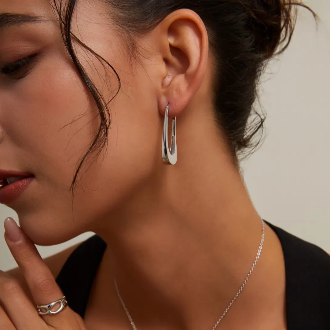 Model wearing S925 Silver Minimalist U-Shaped Drop Earrings in silver with a delicate necklace and black top