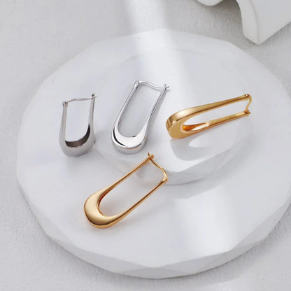 S925 Minimalist U-Shaped Drop Earrings in gold tone on a white curved stand