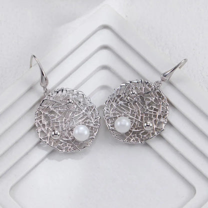 Silver Metal Openwork Personalized Pearl Earrings in silver on white geometric background